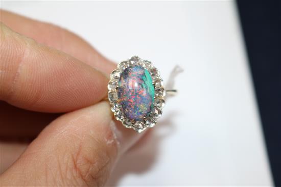 A yellow metal, opal and diamond oval cluster ring, size O.